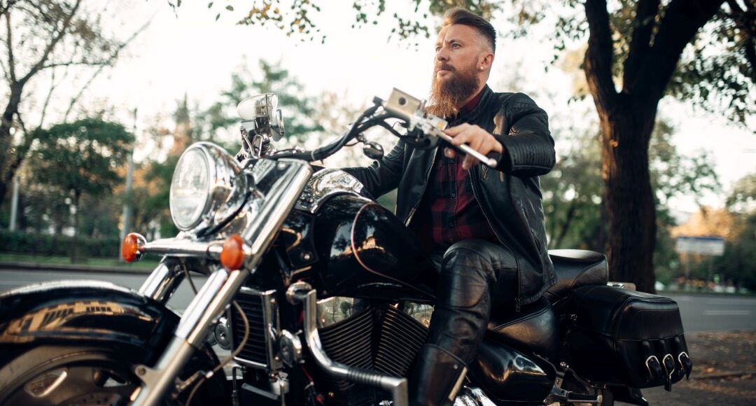 Biker sitting on a motorcycle leaning on a helmet